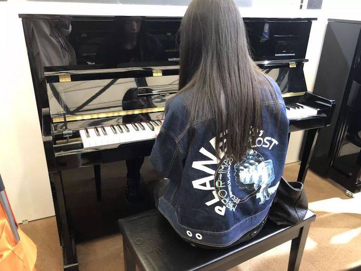 参观来宾试奏热博钢琴